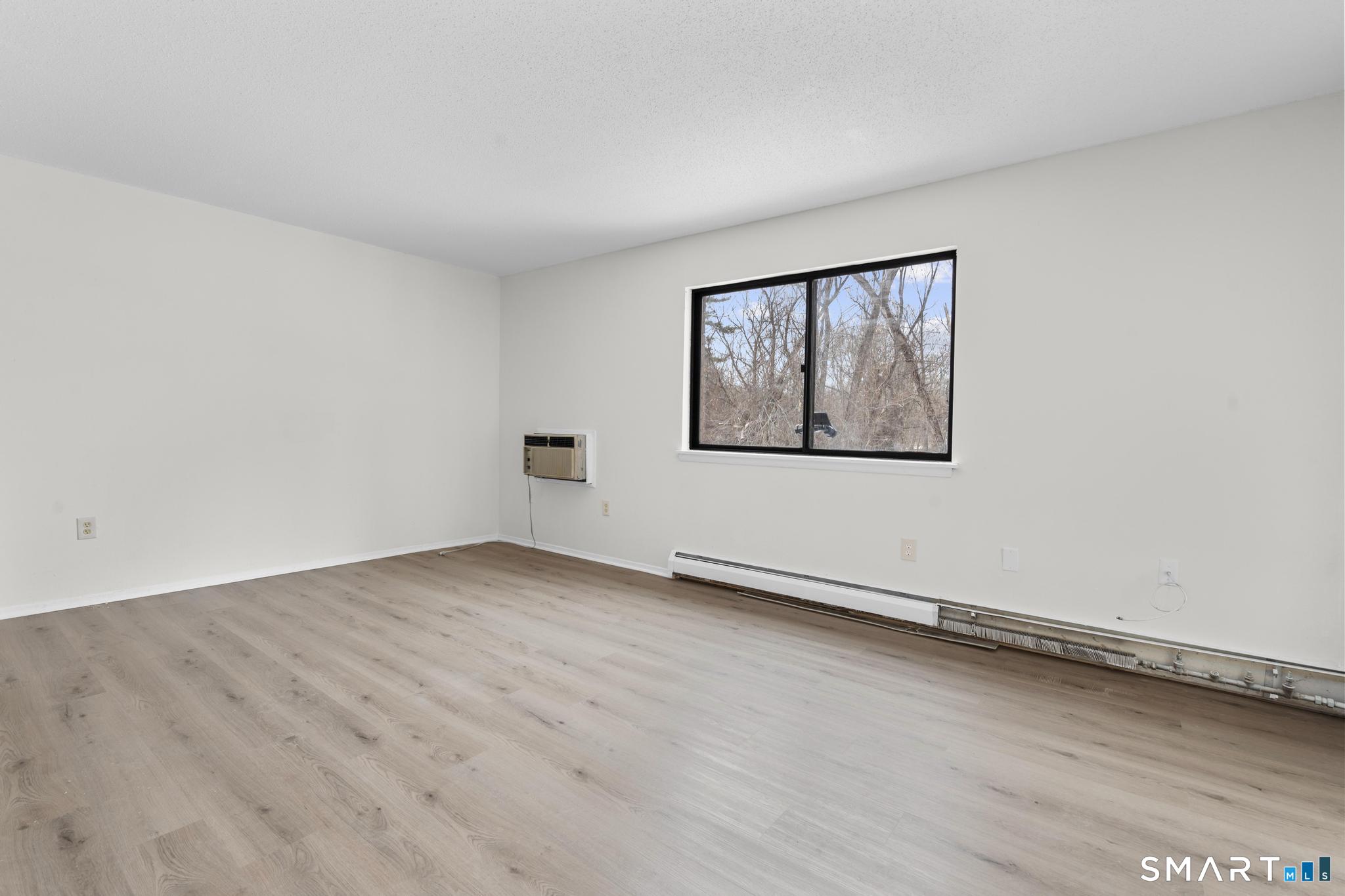 83 Sutton Place, Unit 83 Bloomfield, CT 06002 - Photo 21 of 29 an empty room with wooden floor and windows