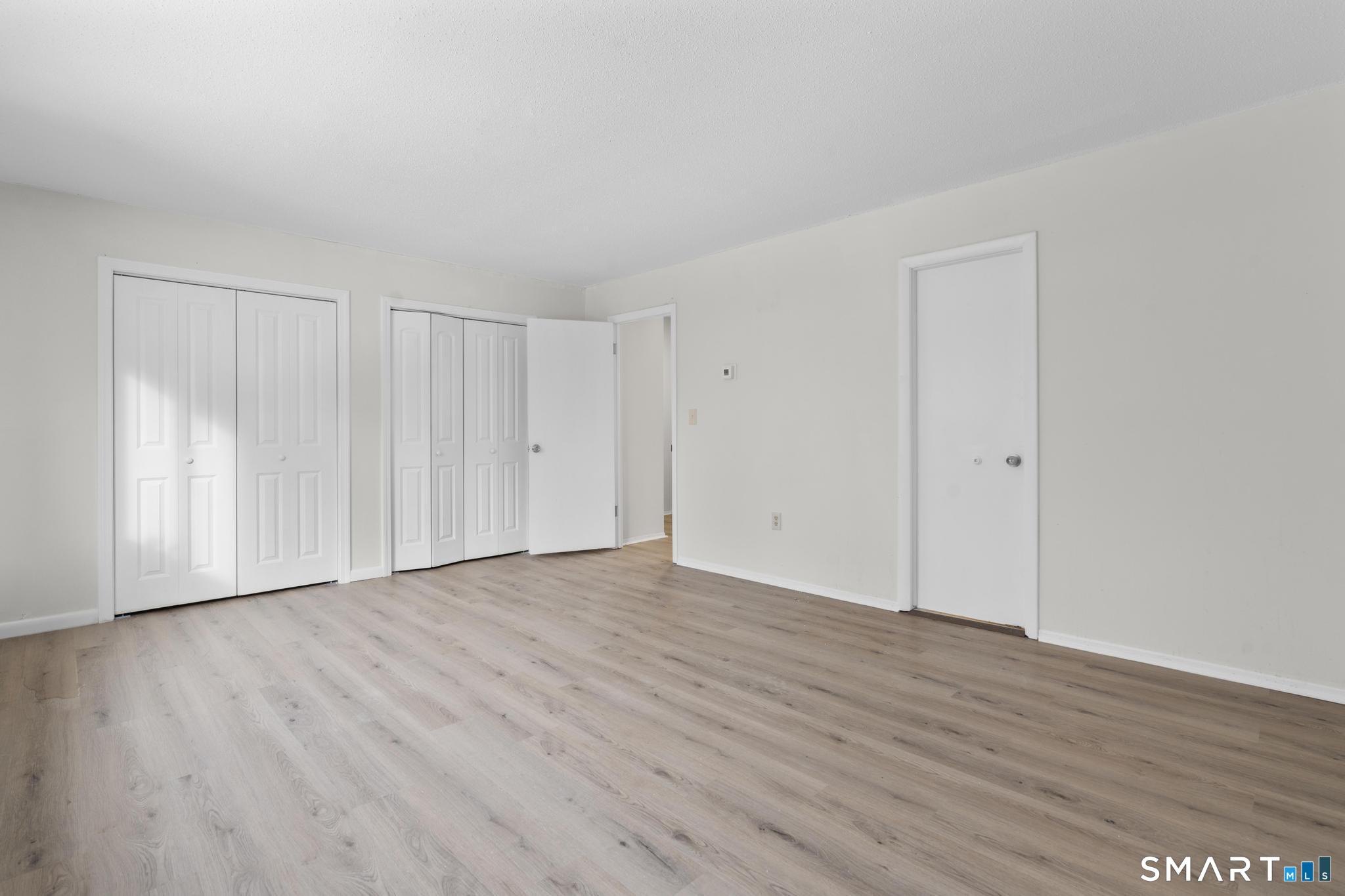 83 Sutton Place, Unit 83 Bloomfield, CT 06002 - Photo 24 of 29 a view of an empty room with wooden floor