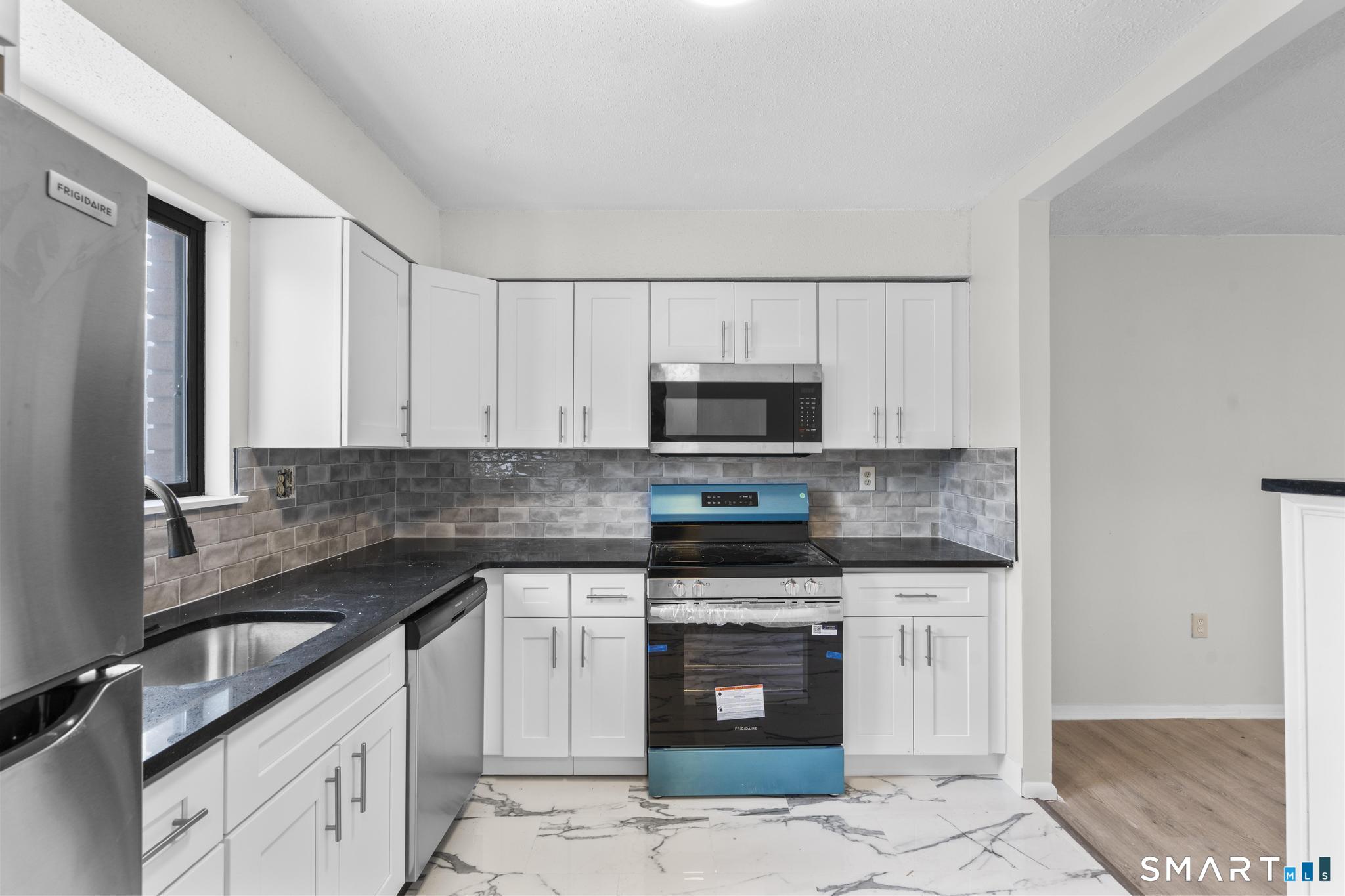 83 Sutton Place, Unit 83 Bloomfield, CT 06002 - Photo 4 of 29 a kitchen with stainless steel appliances granite countertop a stove sink and cabinets
