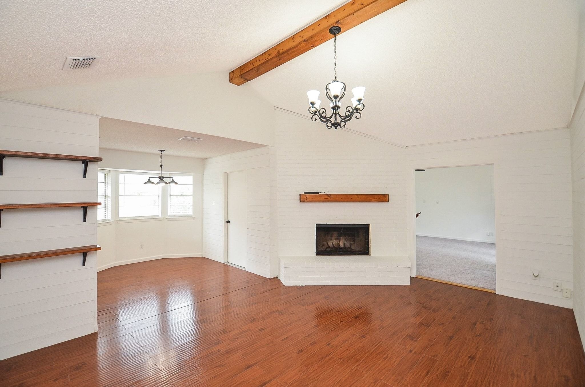 9014 Langfield Road Houston, TX 77040 - Photo 8 of 37 This spacious open-concept living area features high vaulted ceilings anchored by an exposed wooden beam and a wrought-iron chandelier.