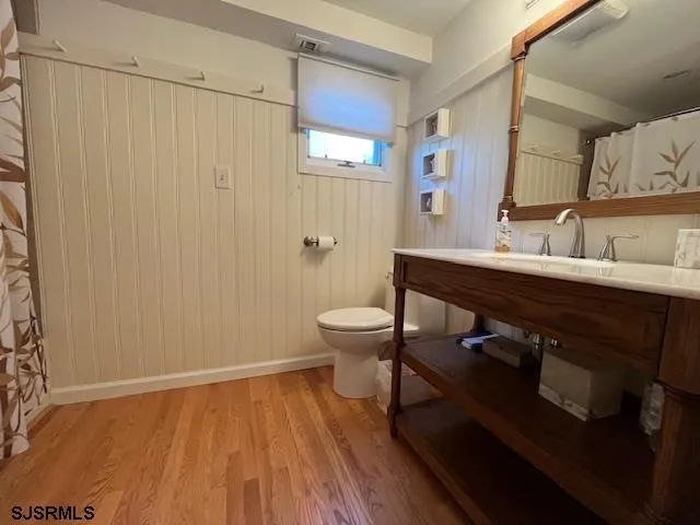 a bathroom with a sink a toilet a mirror and shower
