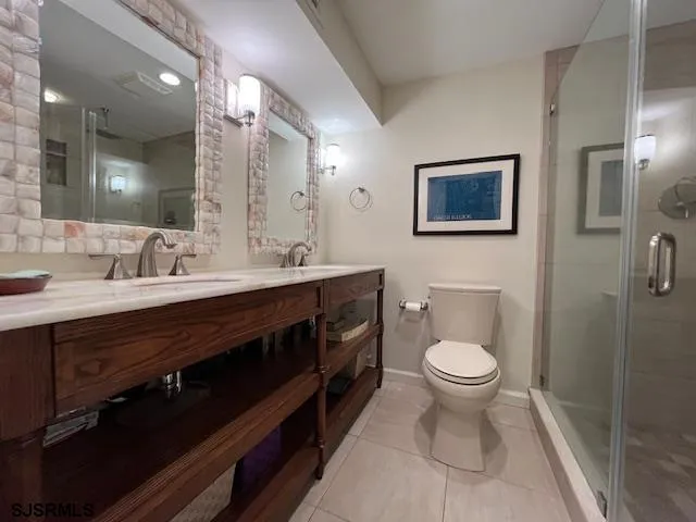 a bathroom with a toilet sink double vanity and mirror