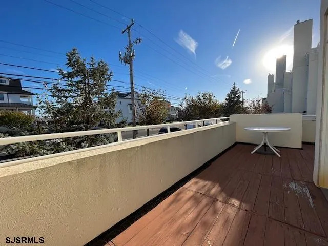 a view of a balcony with chairs and wooden floor