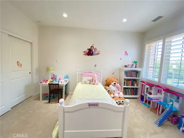 a bedroom with bed and a large window