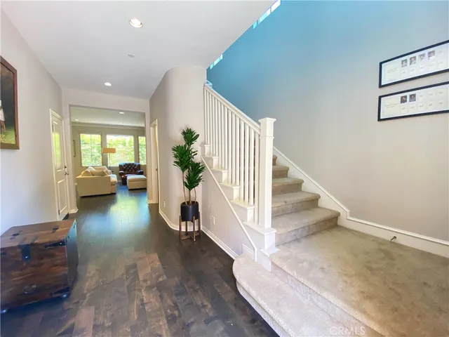 a view of entryway and hall with wooden floor
