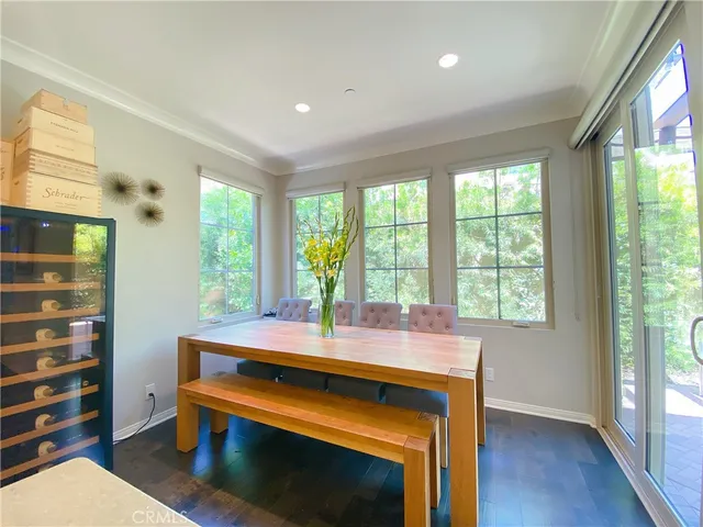 a room with a table chairs and windows