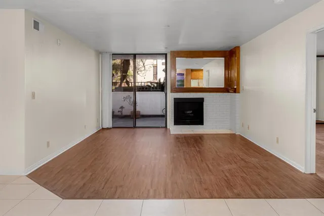 a view of a livingroom with wooden floor and a fireplace