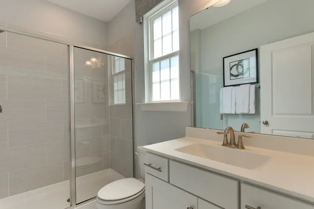 a bathroom with a sink toilet a mirror and shower