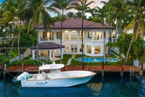 a white house with a table and chairs under an umbrella