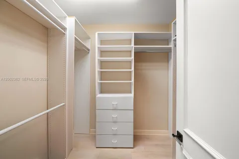 a bedroom with a large bed a potted plant and a window