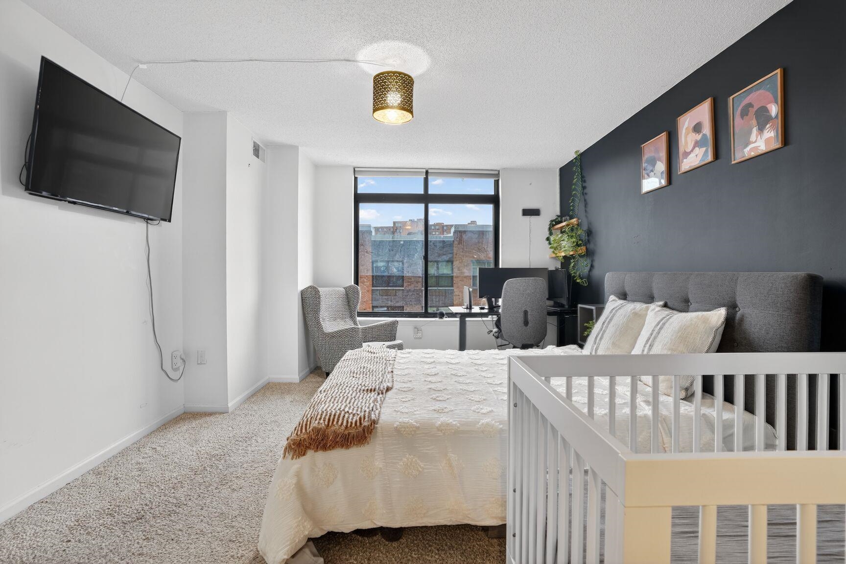 700 1st Street, Unit 7T Hoboken, NJ 07030 - Photo 15 of 25 a bedroom with a bed a flat screen tv and a large window