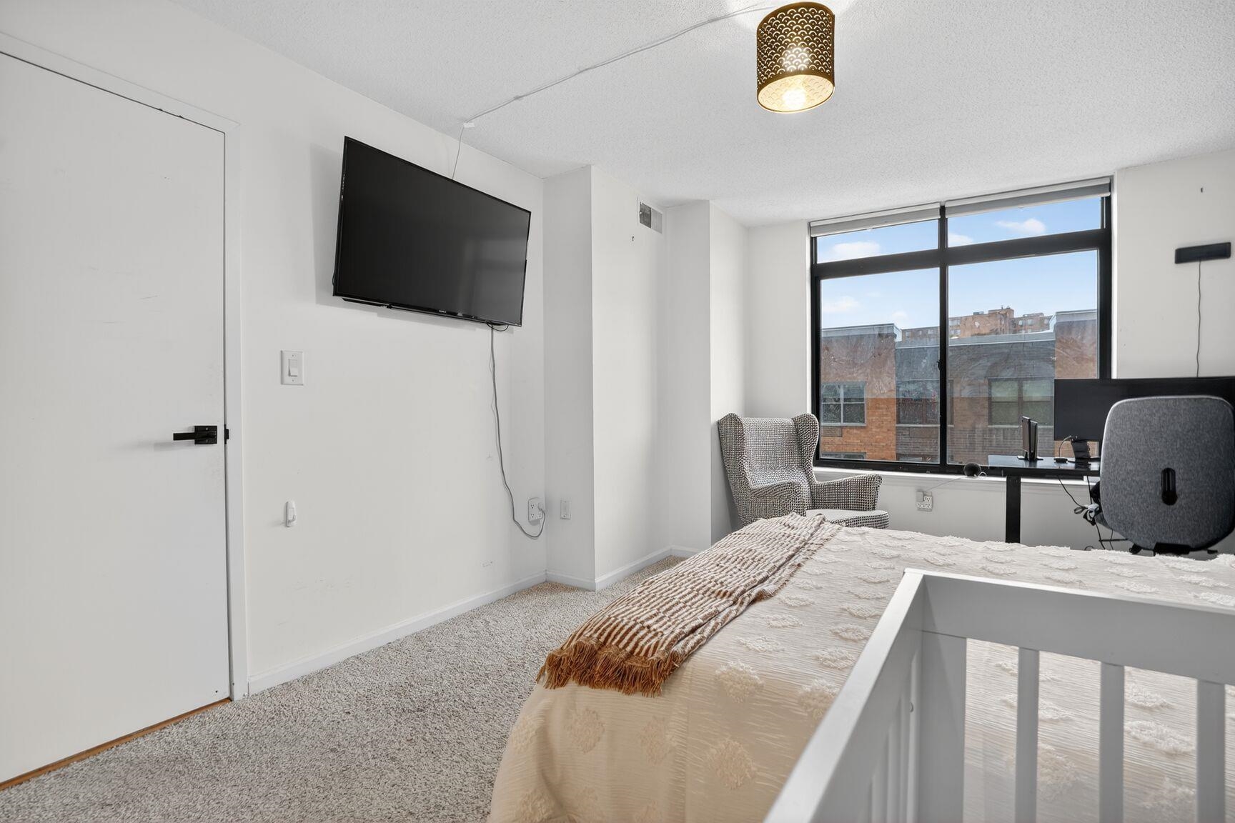700 1st Street, Unit 7T Hoboken, NJ 07030 - Photo 16 of 25 a bedroom with a bed and a flat tv screen on the dresser