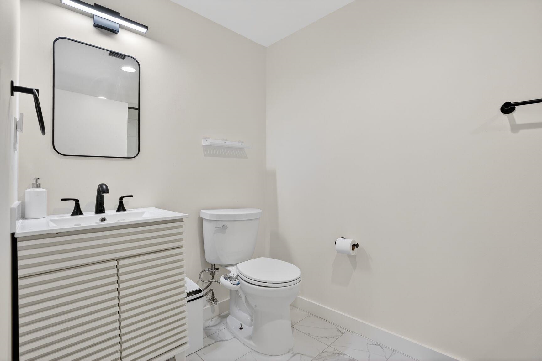 700 1st Street, Unit 7T Hoboken, NJ 07030 - Photo 24 of 25 a bathroom with a toilet a sink a mirror and vanity