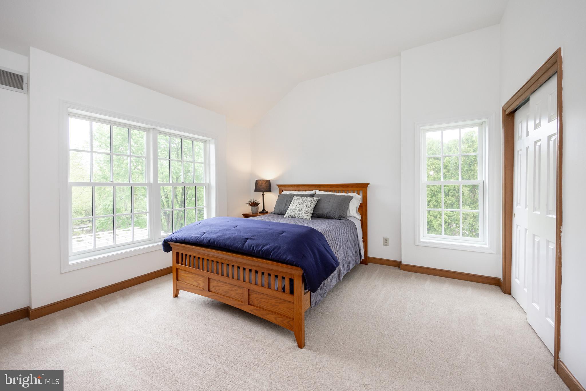 10 Brampton Road Malvern, PA 19355 - Photo 33 of 49 a spacious bedroom with a bed lamp and a large window