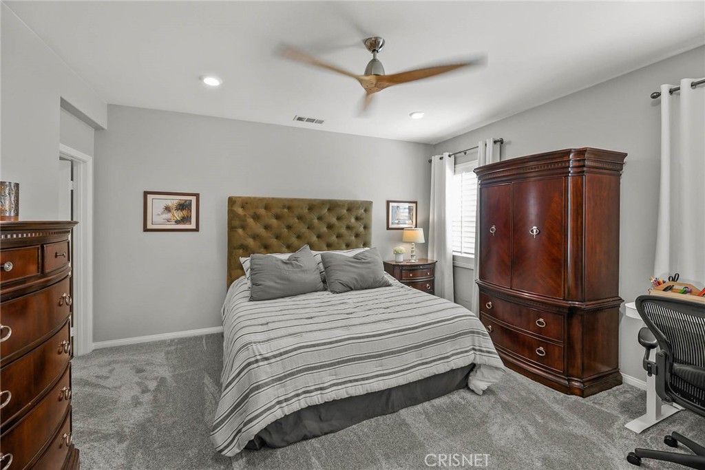 19663 Griffith Drive Saugus, CA 91350 - Photo 15 of 28 a bedroom with a bed a refrigerator and a ceiling fan