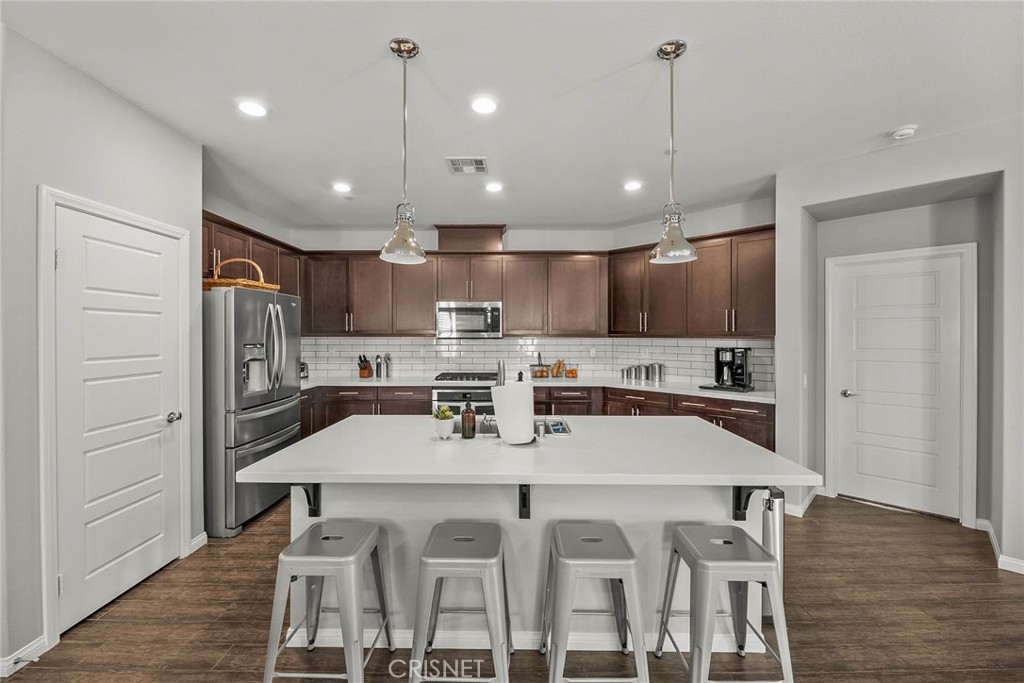19663 Griffith Drive Saugus, CA 91350 - Photo 6 of 28 a kitchen with stainless steel appliances granite countertop a sink refrigerator and cabinets