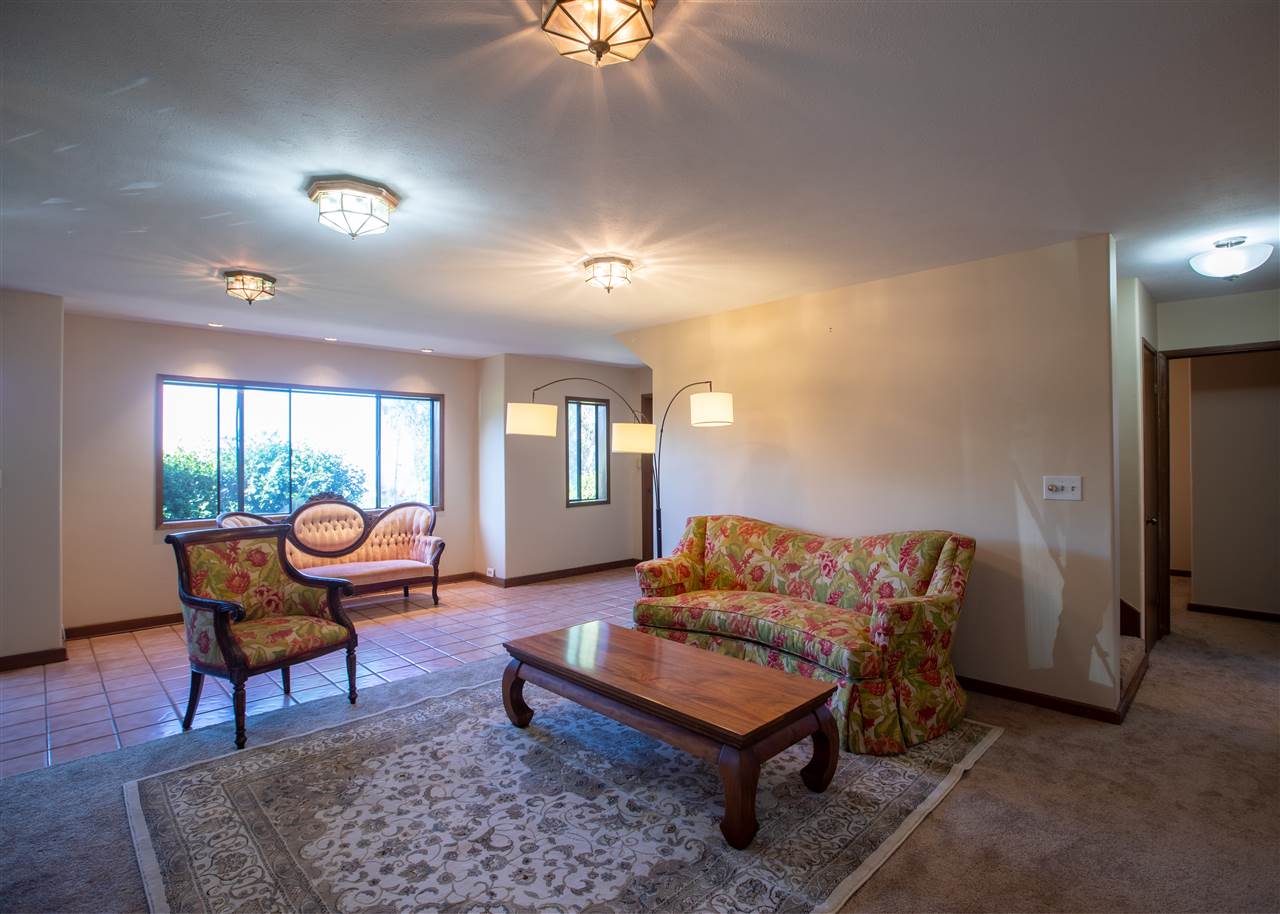 586 Naalae Road Kula, HI 96790 - Photo 11 of 30 a living room with furniture a piano and a window