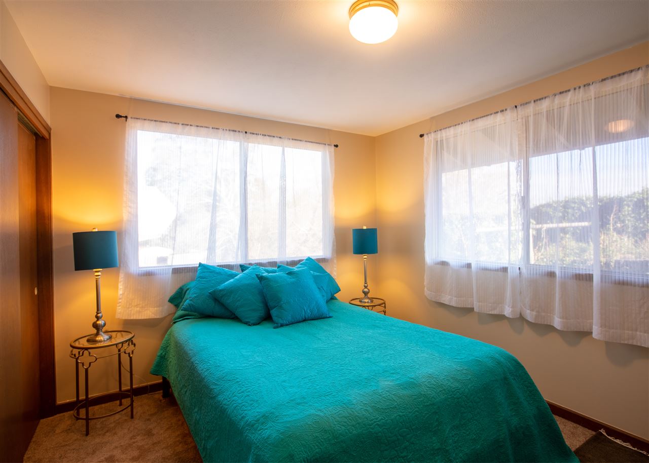 586 Naalae Road Kula, HI 96790 - Photo 15 of 30 a bedroom with a bed and large windows