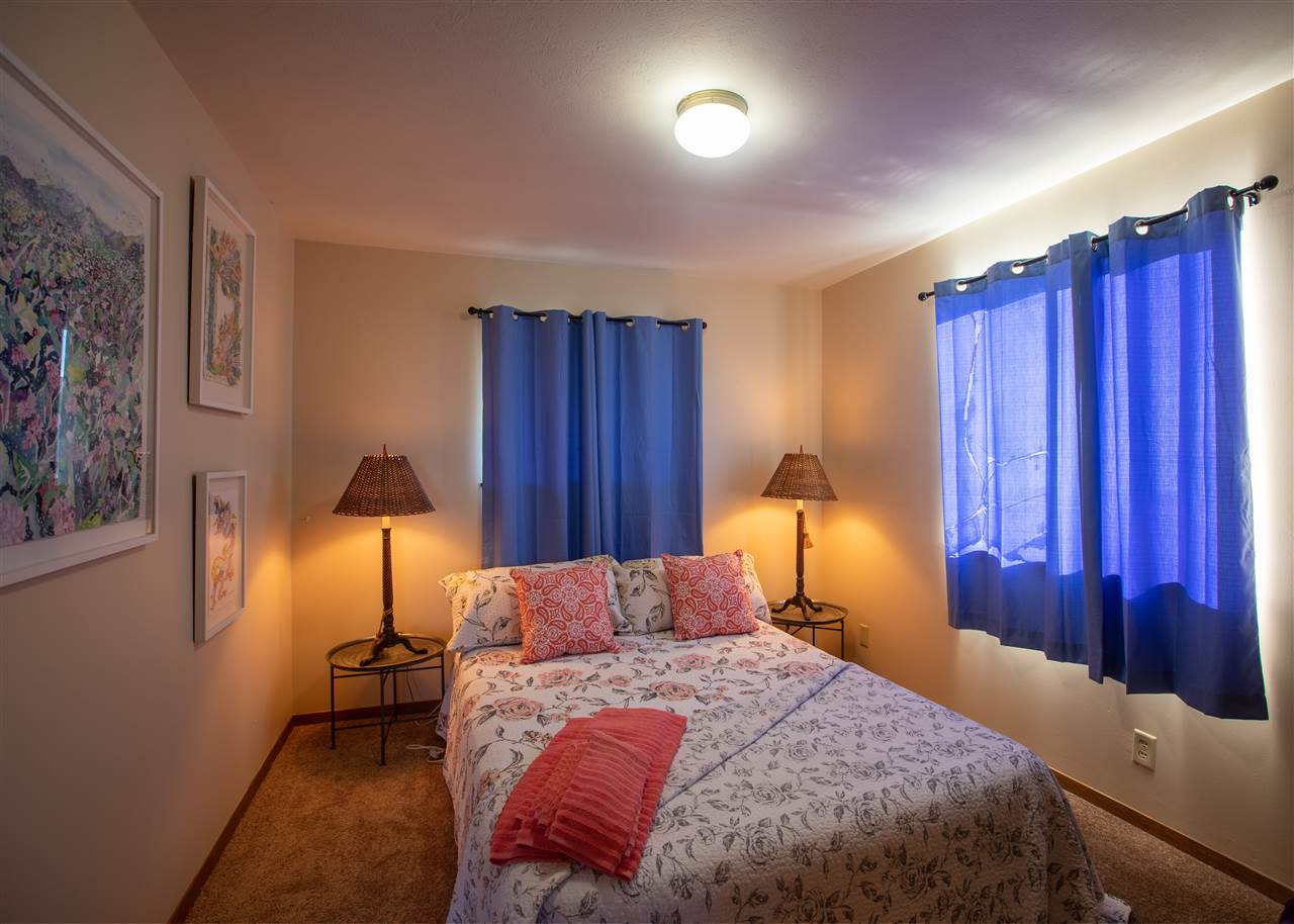 586 Naalae Road Kula, HI 96790 - Photo 19 of 30 a bed room with a bed and a lamp