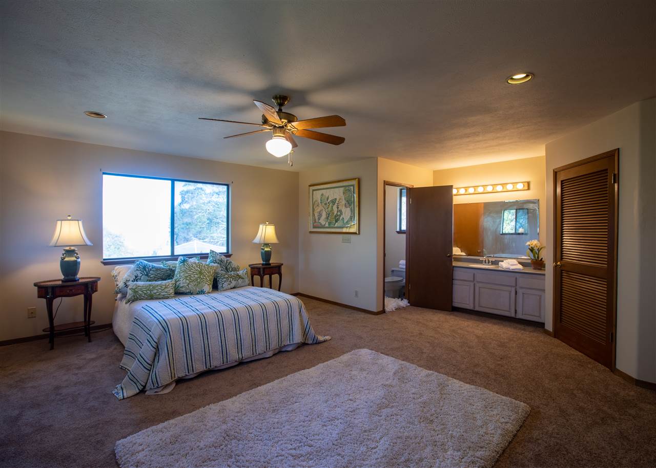 586 Naalae Road Kula, HI 96790 - Photo 22 of 30 a bedroom with a bed a chandelier and a couch
