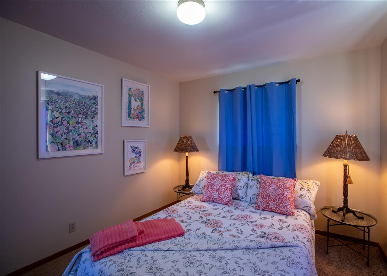 586 Naalae Road Kula, HI 96790 - Photo 25 of 30 a bedroom with a bed and a lamp