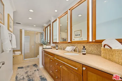a spacious bathroom with a double vanity sink a mirror and a shower