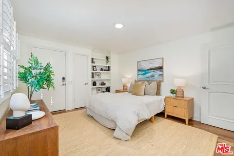 a bedroom with a bed and a potted plant