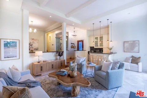 a living room with furniture and a view of kitchen