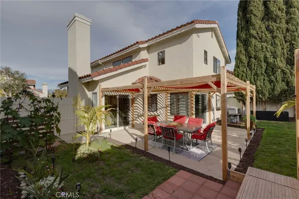 a view of a house with backyard sitting area and garden