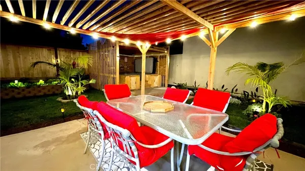 a view of a patio with couches table and chairs and potted plants