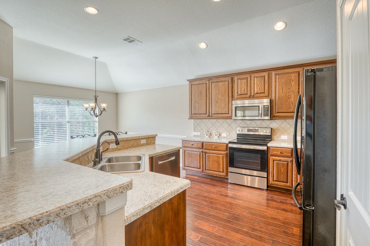 1403 Adam Burnet, TX 78611 - Photo 11 of 30 a kitchen that has a sink cabinets counter space and appliances