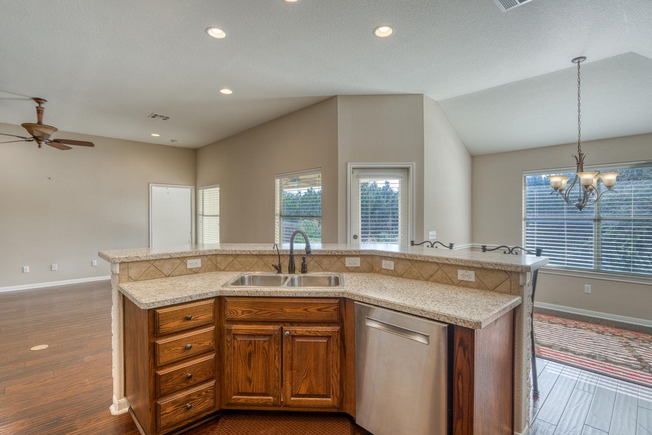 1403 Adam Burnet, TX 78611 - Photo 12 of 30 a bathroom with a granite countertop sink a large mirror and a bathtub