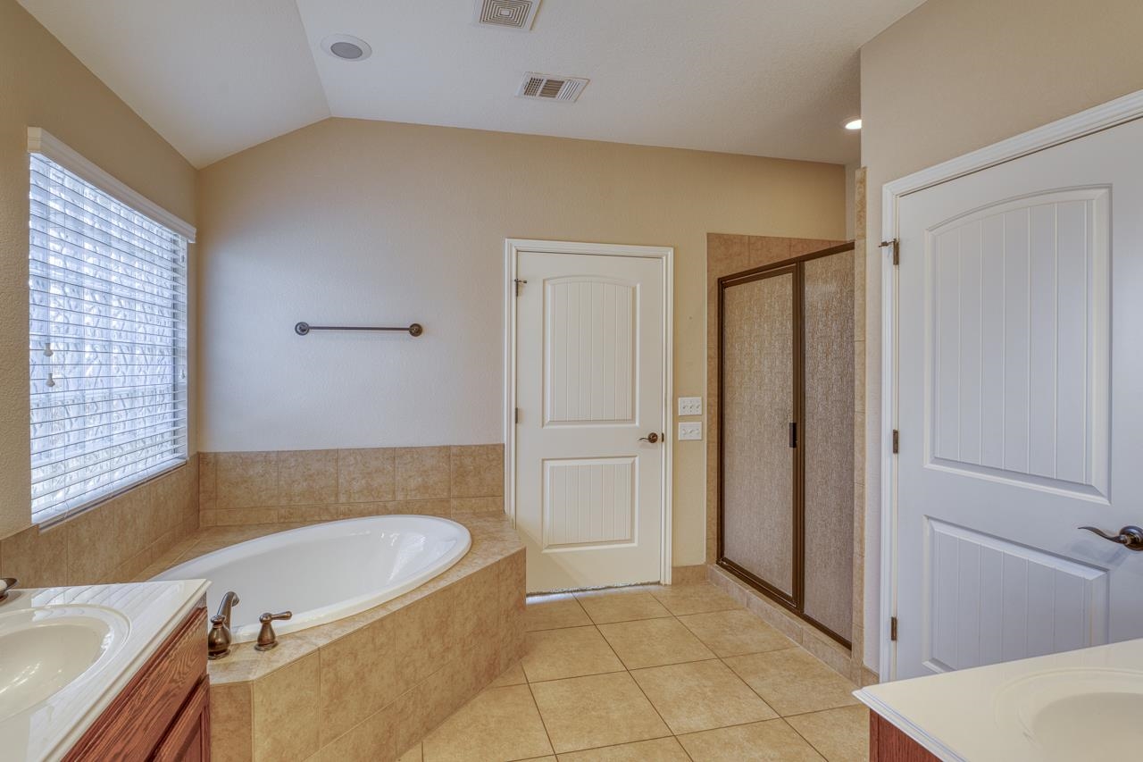 1403 Adam Burnet, TX 78611 - Photo 18 of 30 a bathroom with a tub a sink and a shower