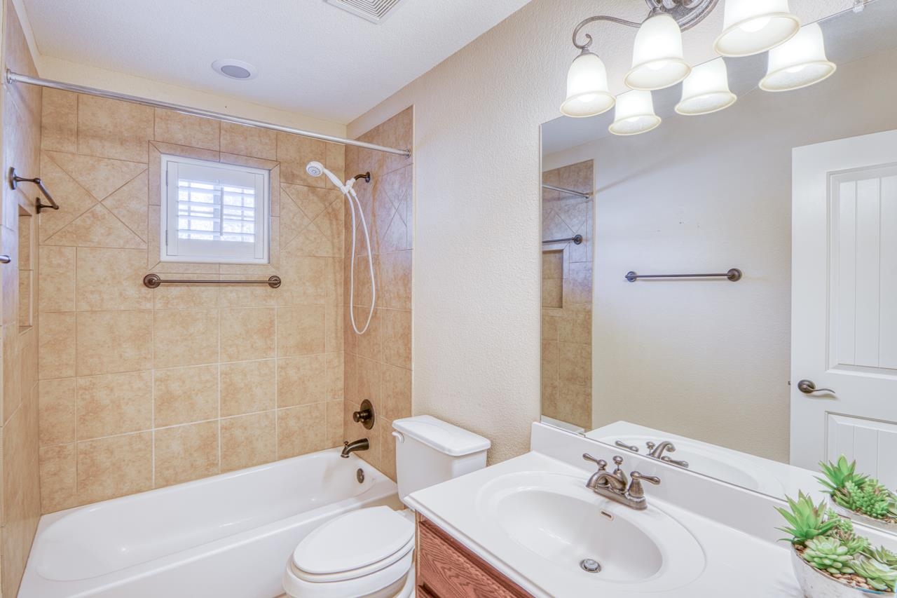 1403 Adam Burnet, TX 78611 - Photo 20 of 30 a bathroom with a sink a toilet a mirror and shower