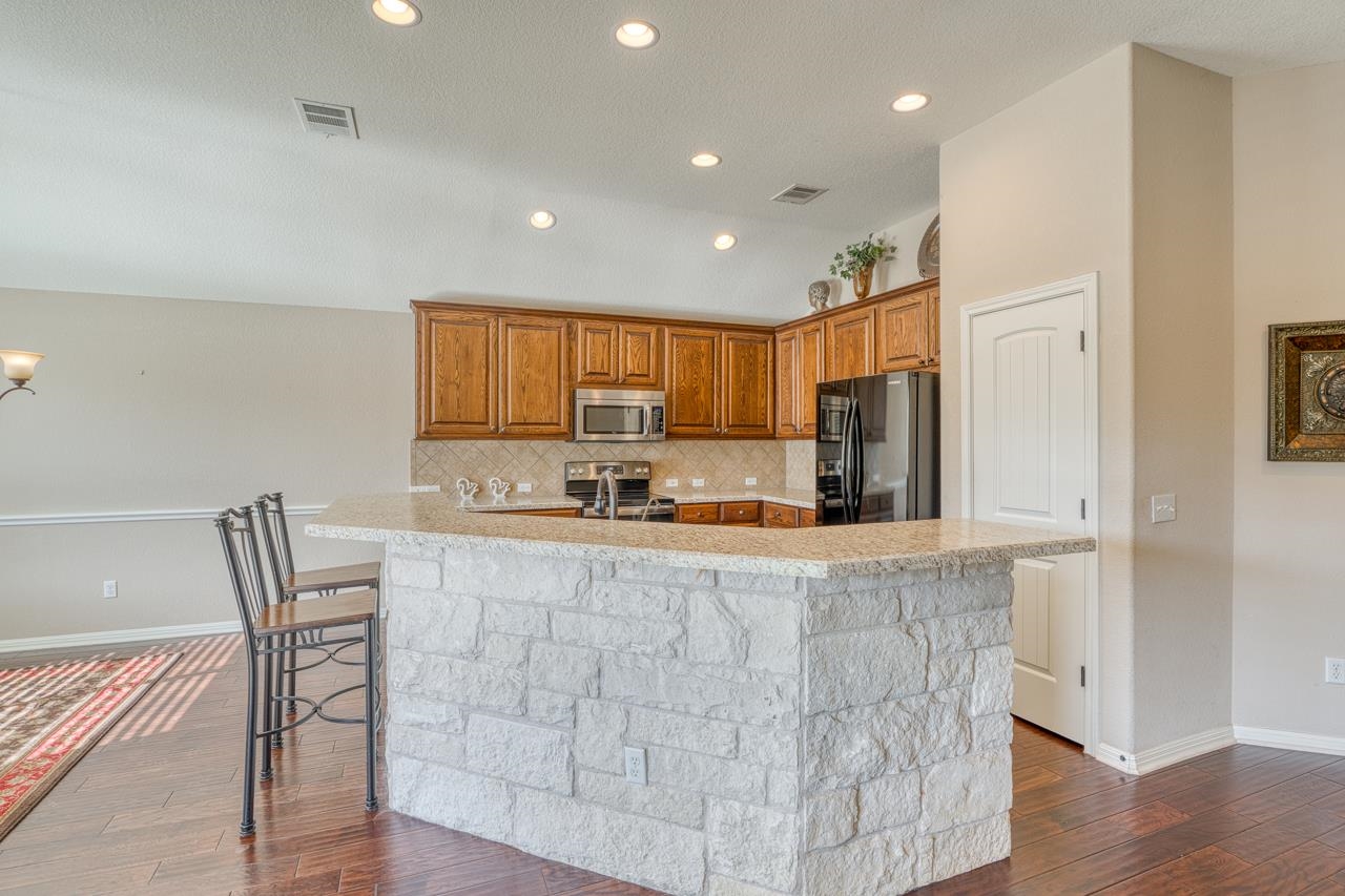 1403 Adam Burnet, TX 78611 - Photo 10 of 30 a large kitchen with stainless steel appliances a large counter top space and cabinets