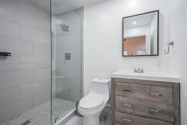 a bathroom with a granite countertop toilet sink and mirror