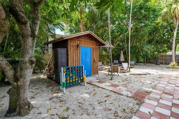 a view of wooden house with a yard and sitting area