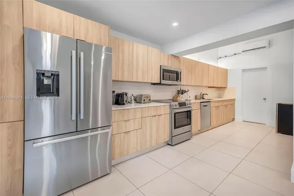 a kitchen with stainless steel appliances a refrigerator sink and cabinets