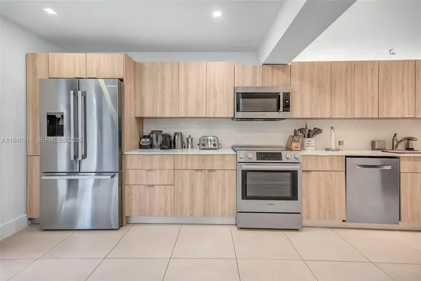 a kitchen with a refrigerator a stove a microwave and cabinets