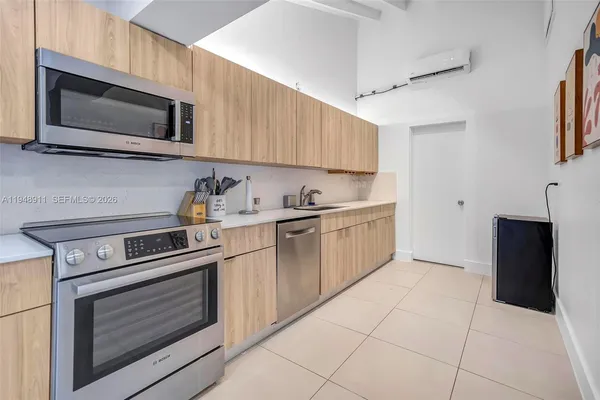 a kitchen with cabinets stainless steel appliances and wooden floor