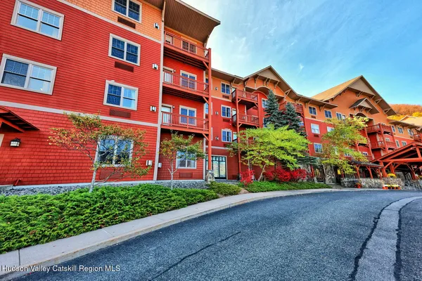 a front view of a building with a yard and potted plants