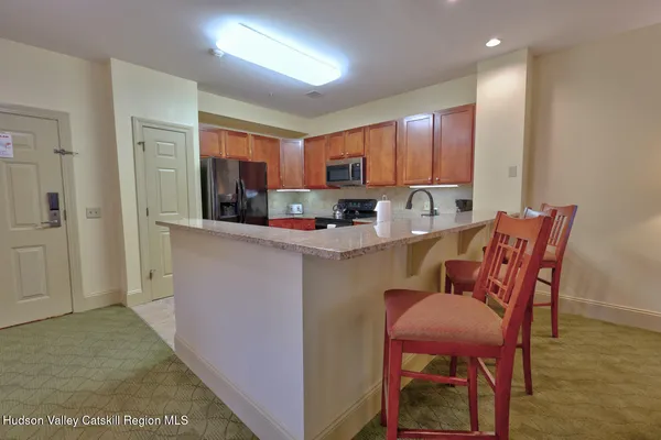 a kitchen with kitchen island a dining table chairs cabinets a sink and a window