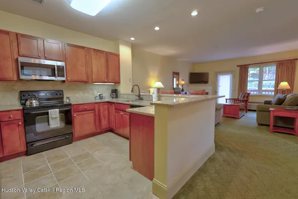 a kitchen with kitchen island a stove sink microwave and cabinets