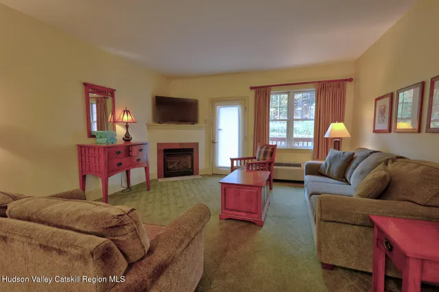 a living room with furniture a flat screen tv and a fireplace