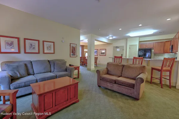 a living room with furniture and a view of kitchen