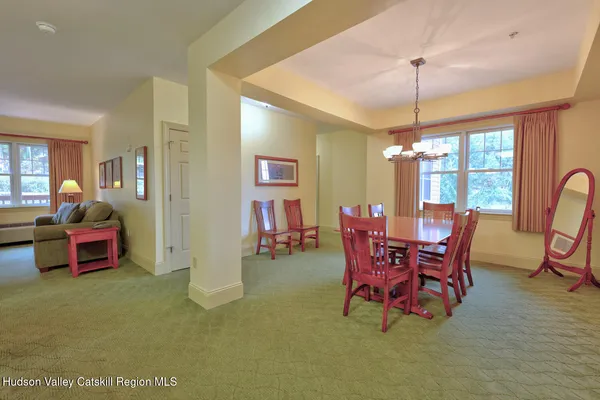 a dining room with furniture chandelier and glass door