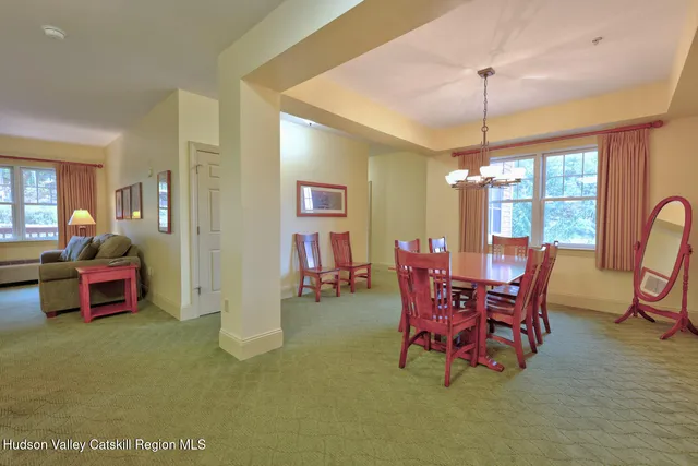 a dining room with furniture chandelier and glass door