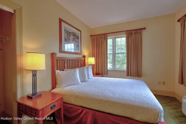 a bedroom with a bed and a lamp on table