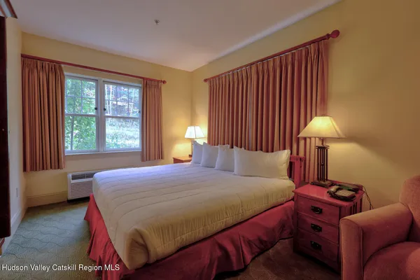 a bedroom with a bed and a lamp