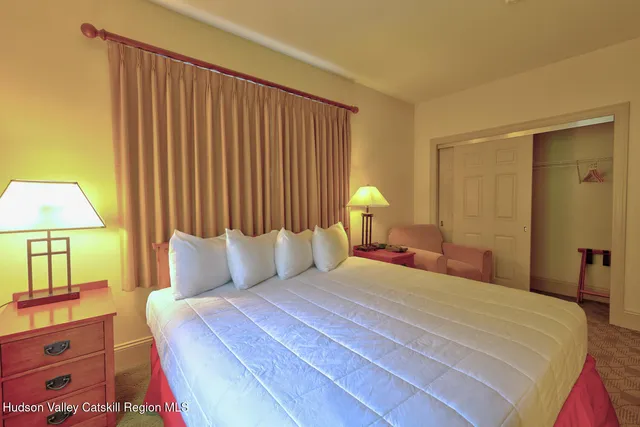 a bedroom with a bed and a lamp